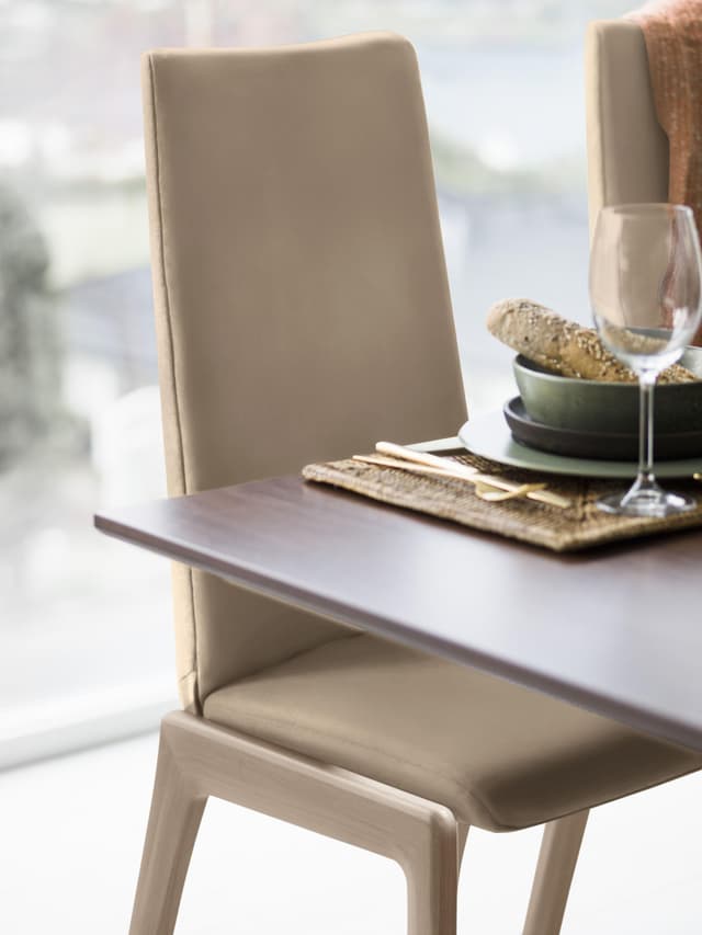 Komfortabler Hocker mit hoher Rückenlehne und abgerundeten schwarzen Beinen